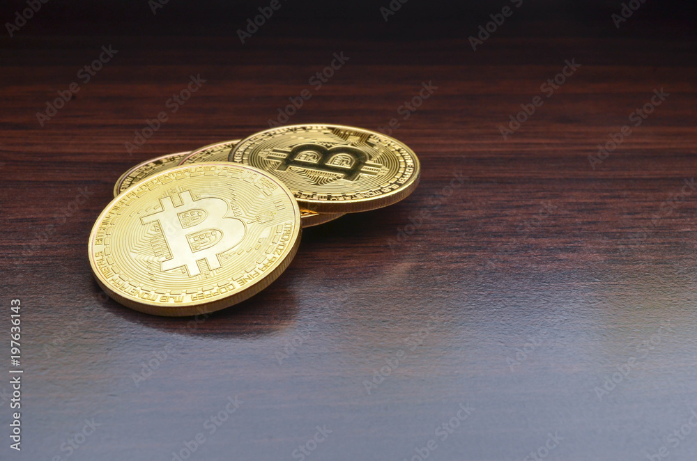 Golden Bitcoins on wooden desk background. Selective focus. Golden Bitcoins on wooden desk background. Selective focus.