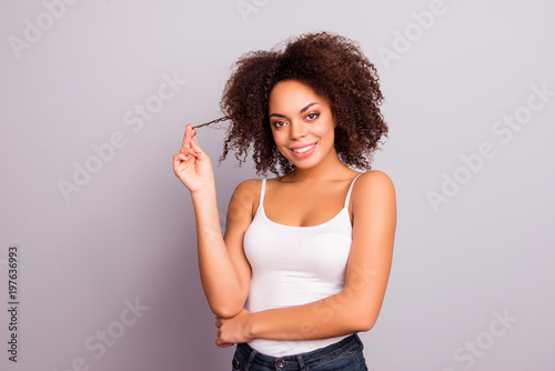 Portrait of passion, sweet, brunette, cute, nice, sexy, flirting, coquette, bachelorette, girl winding strand of hair on finger, looking at camera, isolated on grey background