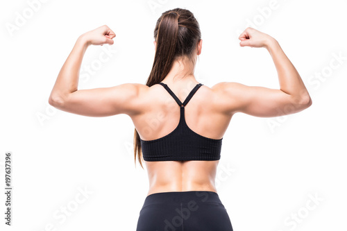Athletic young woman showing muscles of the back and hands on isolated white background
