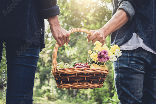 Couple in love walking and holding a picnic basket on nature outdoor background