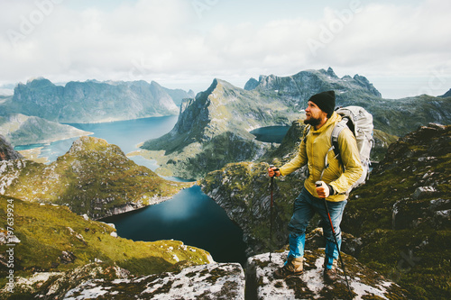 Bearded man traveler standing on cliff mountain in Norway Traveling with backpack healthy lifestyle adventure concept hiking active summer vacations outdoor