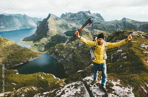 Happy traveler man success raised hands standing on mountain top adventure traveling healthy lifestyle wanderlust concept hiking active summer vacations outdoor in Norway