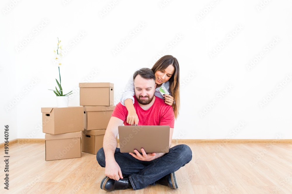 Happy family after moving to a new house choose furniture in the online store Happy family after moving to a new house choose furniture in the online store