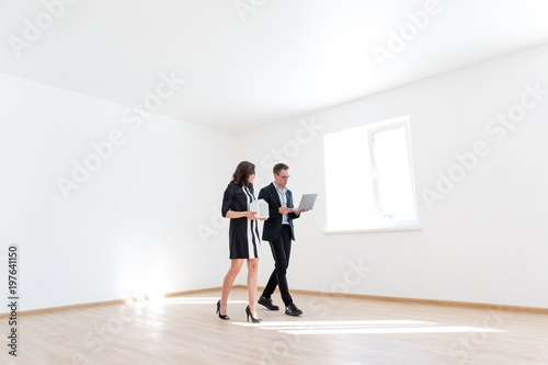 Realtor in glasses shows the buyer a new house