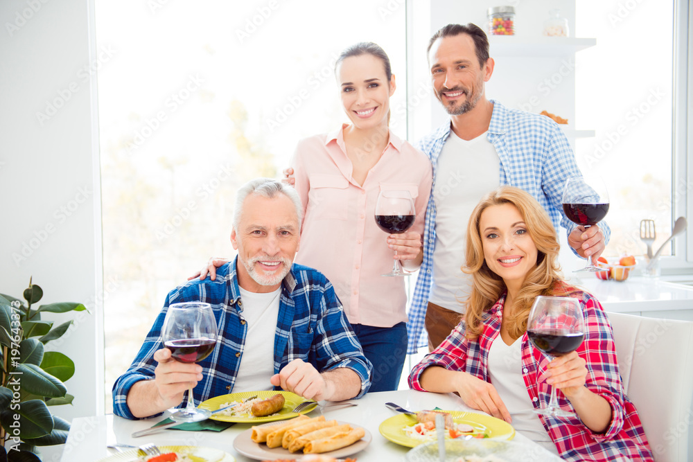 Portrait of beautiful girlfriends, cheerful relatives, attractive, handsome boyfriends having fun in house, room, apartment, drinking wine, eating meals, looking at camera, family photo