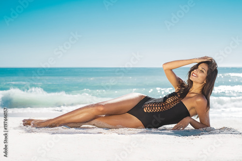 Smiling woman lying on sand