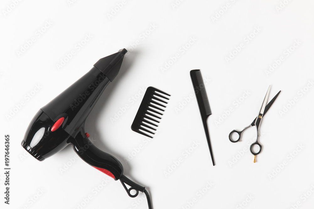 Obraz premium top view of hair dryer, combs and scissors, on white