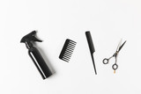 top view of spray bottle, combs and scissors, on white