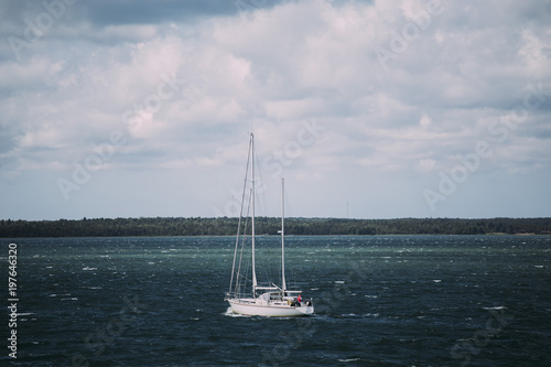 Small Yacht Sailing near coast in windy weather