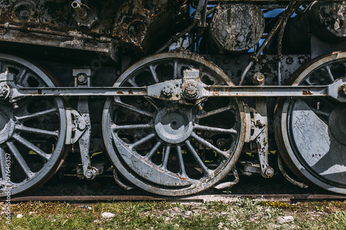 Close up of a steam locomotives iron wheels on a rail track