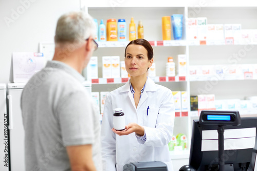 medicine  pharmaceutics  healthcare and people concept - apothecary and senior male customer buying drug at drugstore