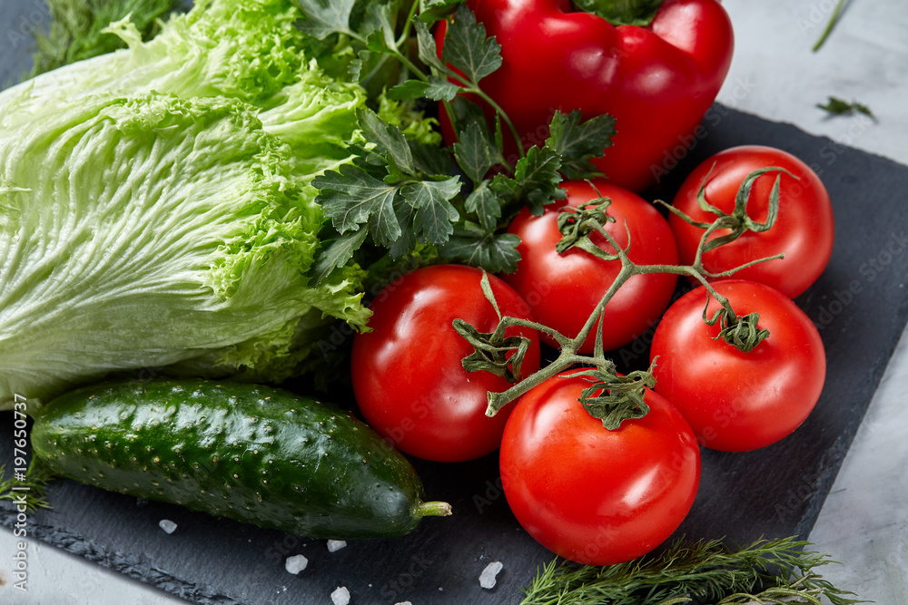 Close-up still life of assorted fresh vegetables and herbs on white textured background, top view, selective focus.