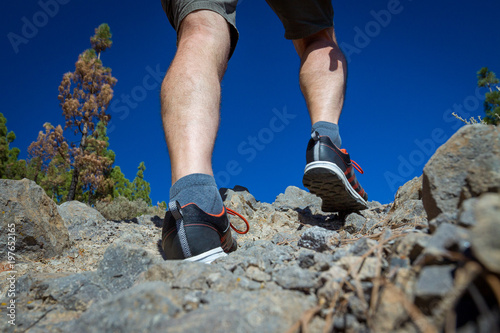 Close up of hikers legs, walking in rocky mountains.