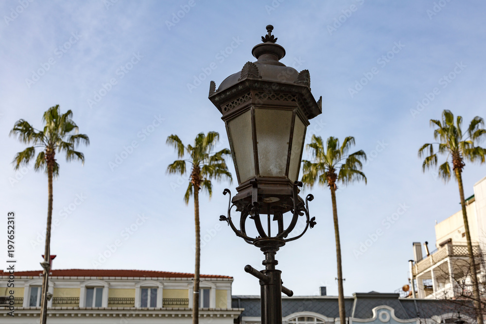 Vintage iron lantern on a city street on a sunny day
