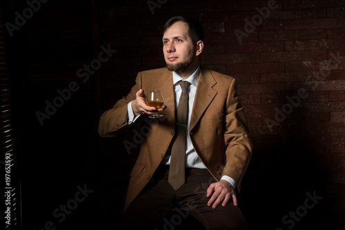 Man in suit tastes expensive cognac