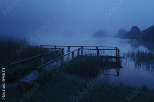 mysterious wooden jetty on lake at night photo