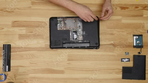 Wallpaper Mural A man disassemble a laptop with a screwdriver. Wooden table top view. Timelapse Torontodigital.ca