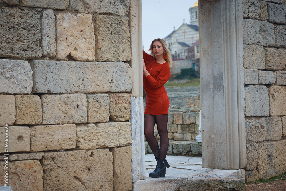 Young hot sexy woman in a short red dress outdoors