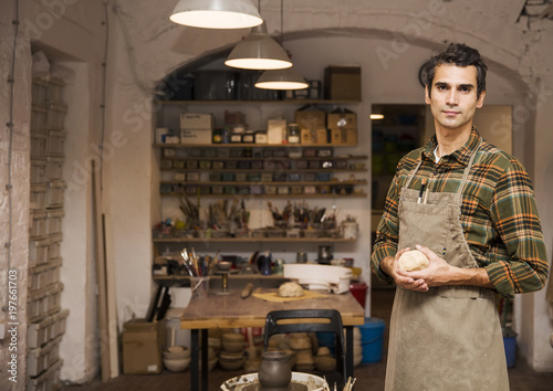 Handsome young man posing in pottery workshop