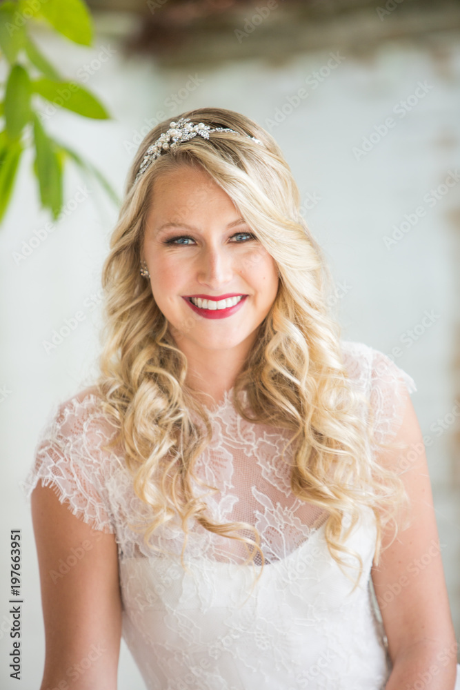 Happy Smiling Bride Looking at the Camera with Lace Dress and Blonde Curly Hair and Red Lips Happy Smiling Bride Looking at the Camera with Lace Dress and Blonde Curly Hair and Red Lips