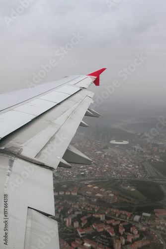 Wing of plane and city under pouring rain. Istanbul, Turkey