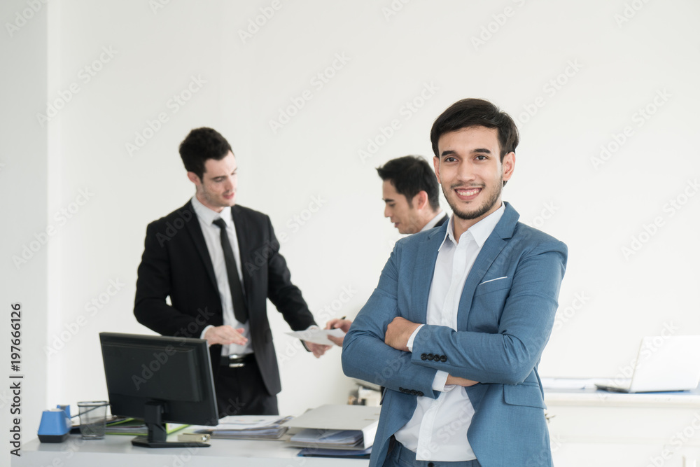 Portrait of business man holding tablet and feeling failed, sad, distraught, frustrated while team mates discussing in the background Portrait of business man holding tablet and feeling failed, sad, distraught, frustrated while team mates discussing in the background
