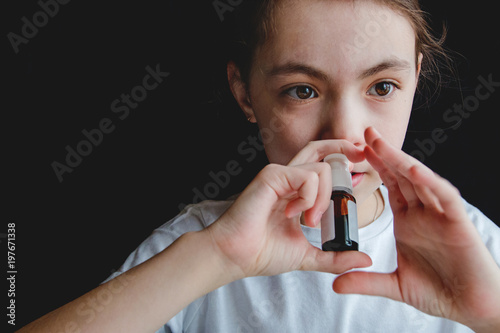 the girl drips into her nose with a spray of cold photo