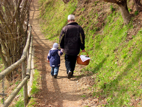 Kleines Kind mit Großvater auf dem Weg zur österlichen Fleischweihe