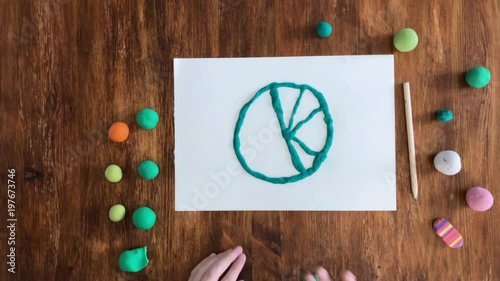 Girl make lemon from plasticine at table, top view, time lapse photo