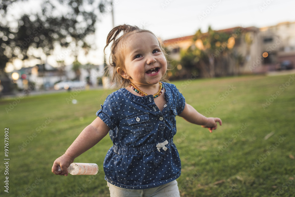 Smiling girl standing on grassy field