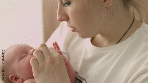 Nurse is rocking newborn baby on the hands