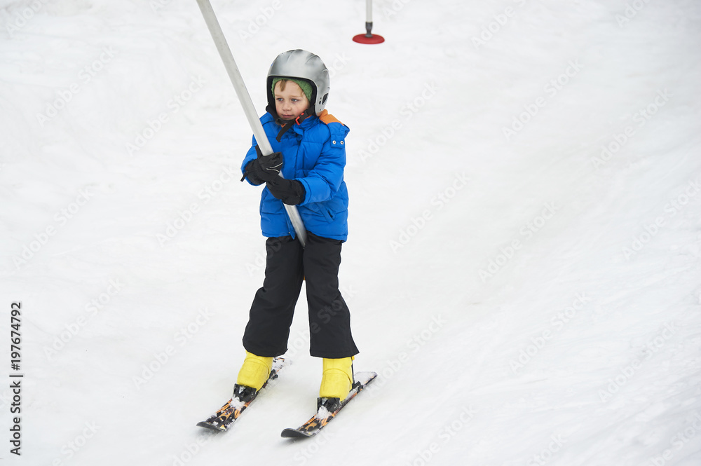 Child boy skiing in winter mountains. Active kid with safety helmet and goggles. Ski race for young children. Winter sport for family. Kids ski lesson in school. Young skier racing in snow Child boy skiing in winter mountains. Active kid with safety helmet and goggles. Ski race for young children. Winter sport for family. Kids ski lesson in school. Young skier racing in snow
