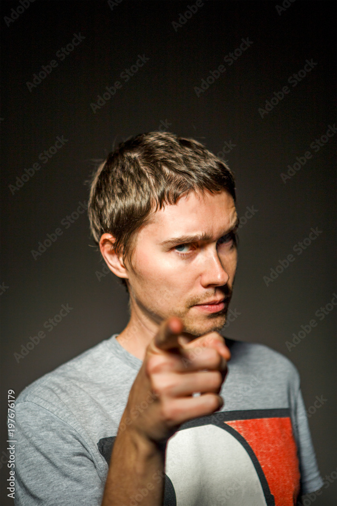 Photo of man in T-shirt showing finger forward Photo of man in T-shirt showing finger forward
