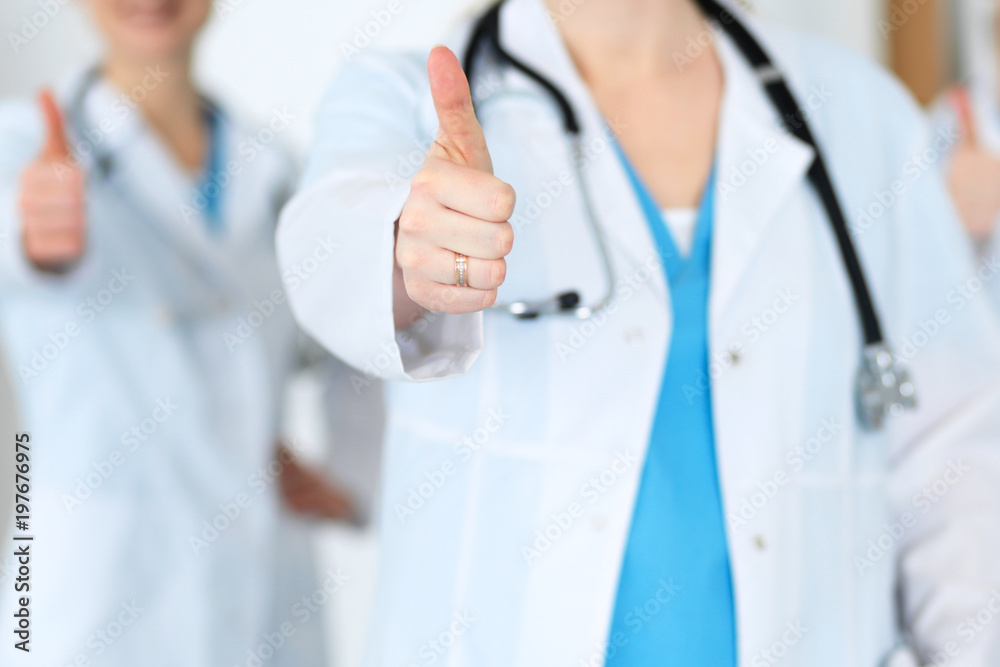 Groupe of medicine doctors show OK sign with thumb up close up. Success and high level service in health care, best treatment and customer loyalty and physical concept. Copy space for advertisement Groupe of medicine doctors show OK sign with thumb up close up. Success and high level service in health care, best treatment and customer loyalty and physical concept. Copy space for advertisement