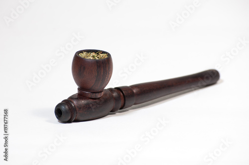 Smoking pipe stuffed with hemp on a white background. Hash pipe.