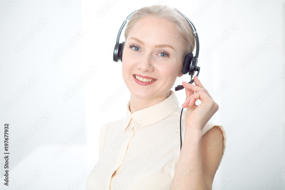 Image of bright call center. Focus on young beautiful woman in a headset Image of bright call center. Focus on young beautiful woman in a headset
