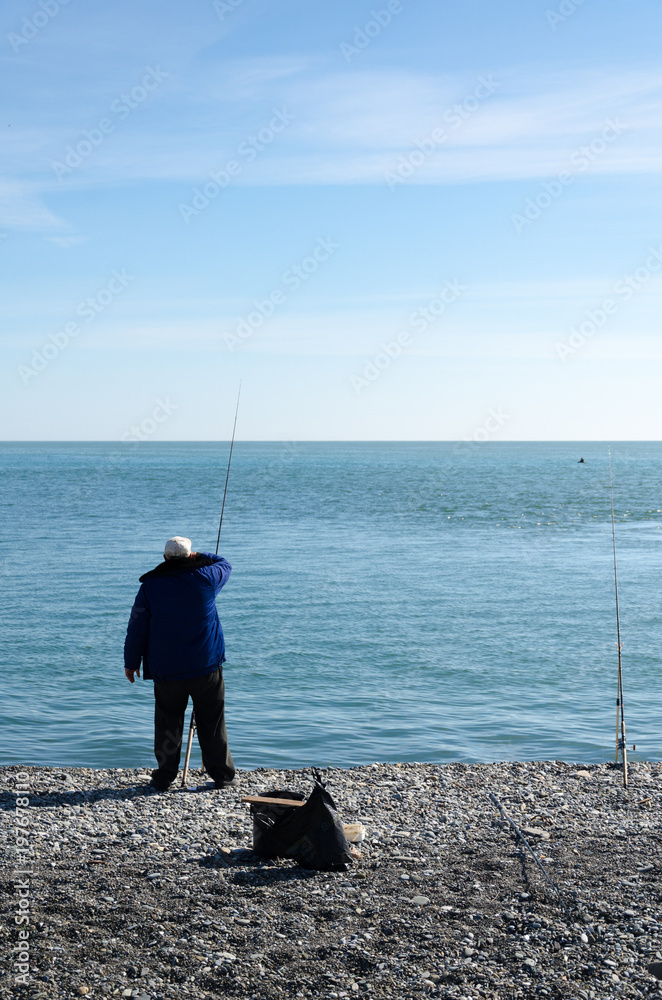 The fisherman is fishing on the shore of the Black Sea.