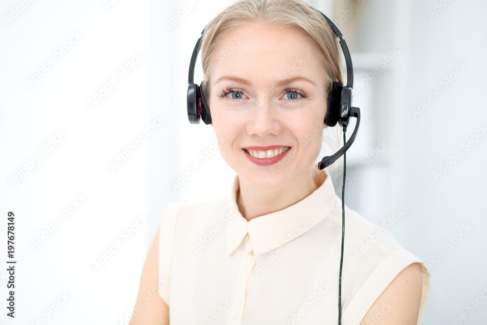 Image of bright call center. Focus on young beautiful woman in a headset Image of bright call center. Focus on young beautiful woman in a headset