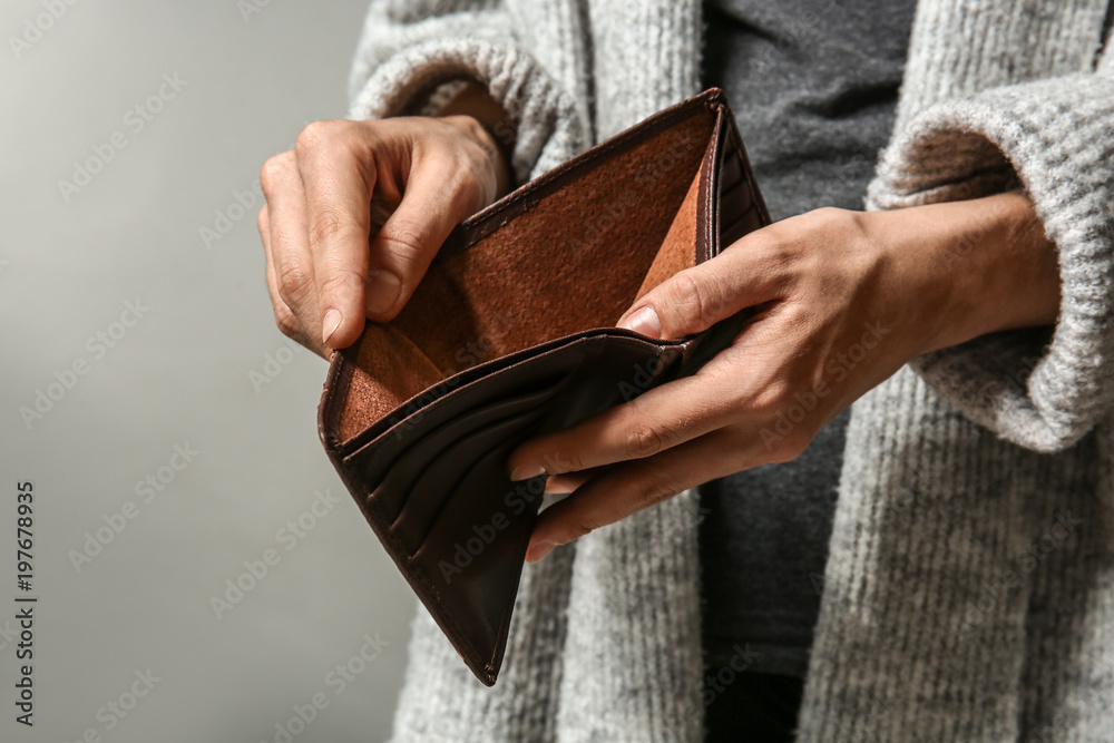 Poor woman showing her empty purse on grey background - obrazy, fototapety, plakaty 
