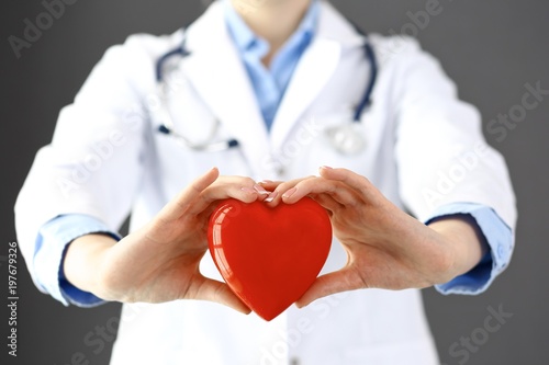 Female doctor with stethoscope holding heart in her arms. Healthcare and cardiology concept  in medicine 