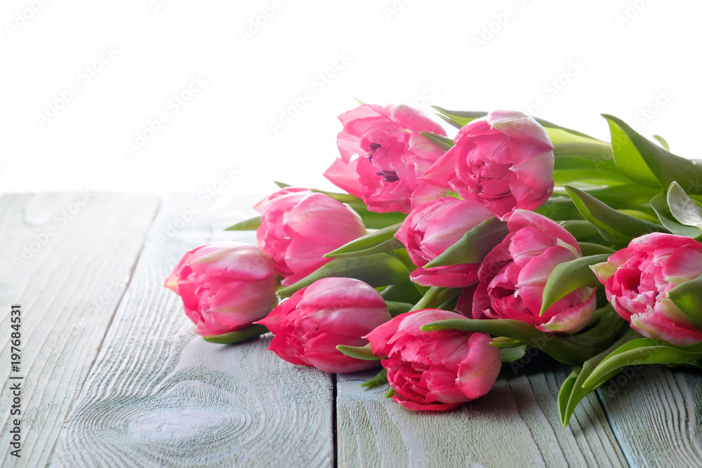 Bouquet of pink tulips on a wooden table, side view