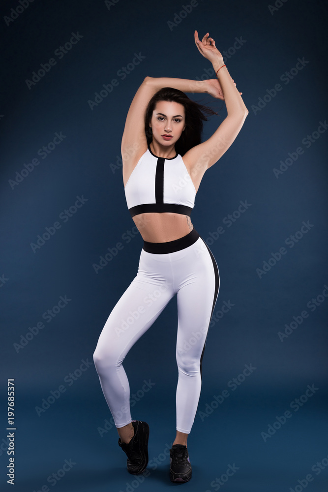 Nothing worth having comes easy! Attractive young sports model in great shape posing for the camera isolated on a dark blue background.