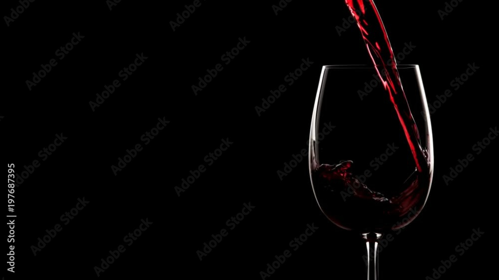 Red wine pouring into glass. Slow motion, silhouette.