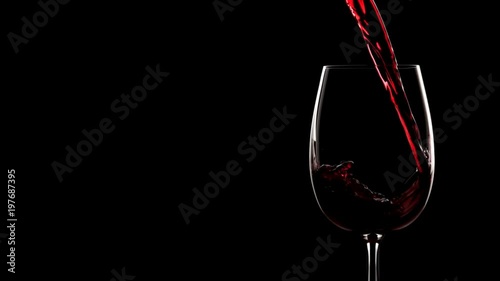 Red wine pouring into glass. Slow motion, silhouette.