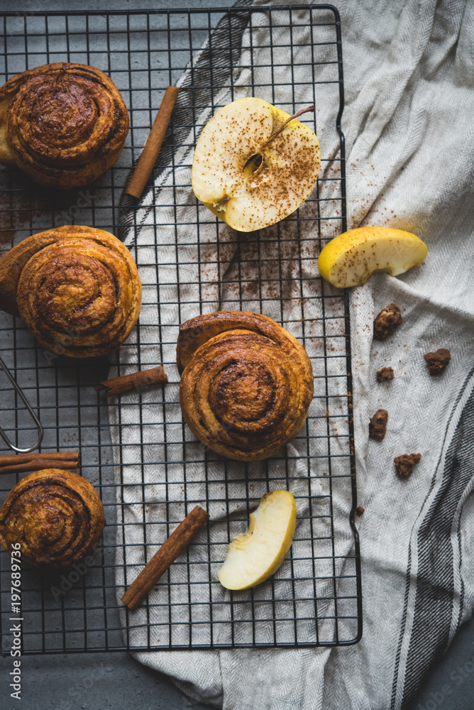 cinnamon rolls on the stone table, decoration with apples and cinnamon