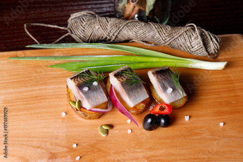 delicious salted herring with herbs and pepper, cut into large pieces photo