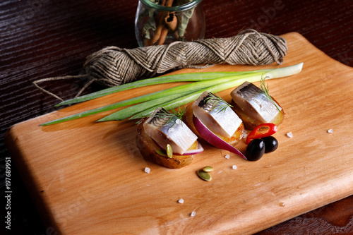 delicious salted herring with herbs and pepper, cut into large pieces photo