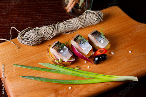 delicious salted herring with herbs and pepper, cut into large pieces photo