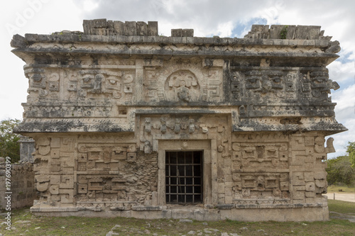 The magician's temple at Mayan ruins Chichen Itza. Impressive Stone building with carved details on every side. The Stone masks on the top floor still show ears, nose and teeth. 