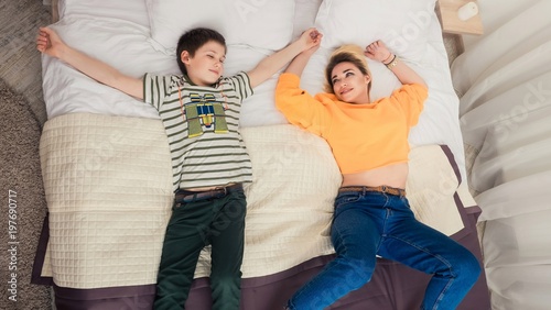 Mother with son on bed, mother and son having fun photo